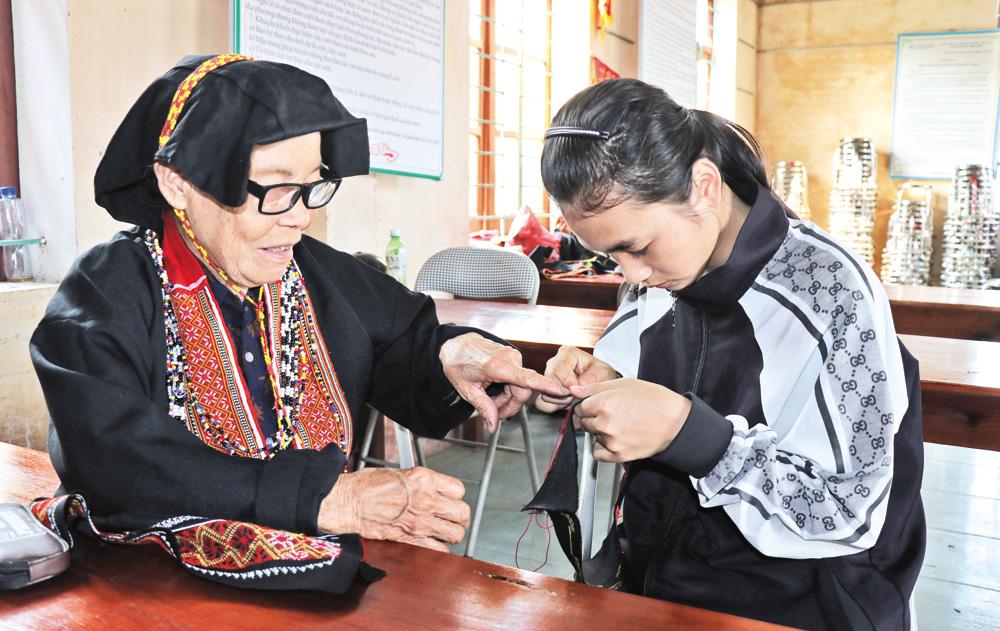 Bà Bàn Thị Bình hướng dẫn kỹ thuật thêu cho lớp trẻ. Bà Bàn Thị Bình hướng dẫn kỹ thuật thêu cho lớp trẻ.